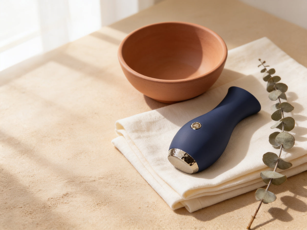 Vibrator CalExotics Chic Tulip bleumarin pe lenjerie de in, în lumină caldă