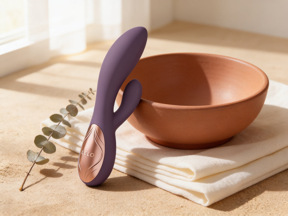 Vibrator rabbit LELO INA Thrust mov, lângă un bol de teracotă